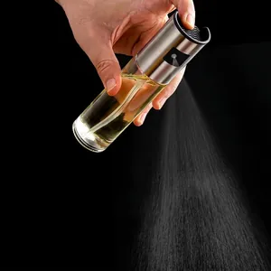 Close-up of stainless steel glass oil sprayer producing fine mist for cooking and BBQ