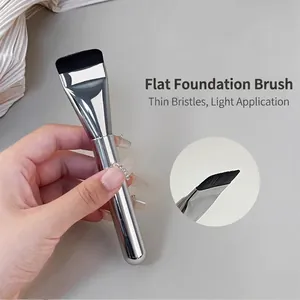 Detail of ultra-thin flat foundation brush with silver metallic handle for seamless makeup