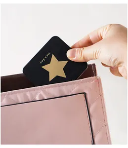 Macro detail of a portable black square makeup mirror being tucked into a pink bag