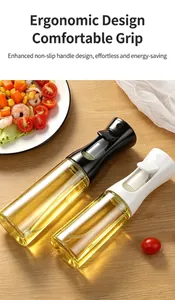 Close-up of black and white glass oil sprayers on wooden table with salad