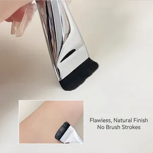Detail of ultra-thin flat foundation brush showing seamless makeup application on skin.