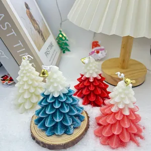 Vue détaillée de quatre bougies parfumées sapin de Noël sur une surface de neige