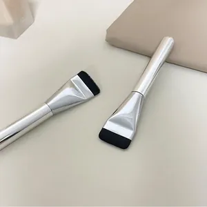Close-up of ultra-thin flat foundation brush with silver handle and black bristles