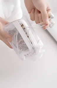 Close-up detail of a white nylon mesh zipper pouch used for storing wired earphones effectively