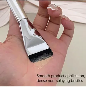 Close-up of an ultra-thin flat foundation brush applying liquid makeup smoothly on skin