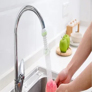 Detalle del aireador de grifo de cocina lavando una manzana roja en un fregadero limpio