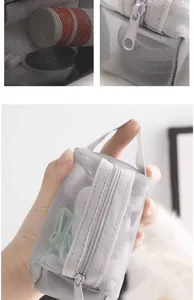 Close-up details of small grey nylon mesh pouch showing zipper and portable handle