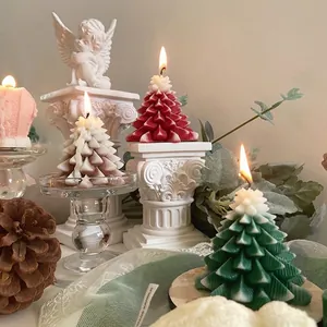 Bougies parfumées artisanales en forme de sapin de Noël sur d'élégantes colonnes romaines