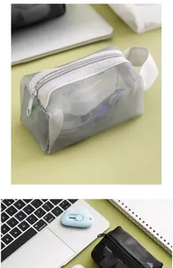 Grey mesh storage pouch on desk with office supplies and blue cloud cutter