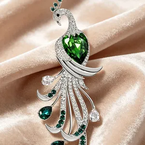 Élégante broche paon avec gemmes vert vif et cristaux étincelants sur fond en velours doux