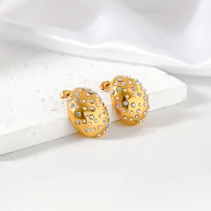 Detail view of gold-plated stainless steel earrings with sparkling rhinestones and pearls