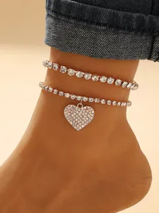 Close-up detail of a double-layer rhinestone anklet featuring a sparkling heart pendant