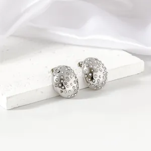 Close-up of oval stainless steel stud earrings with inlaid pearls and rhinestones.
