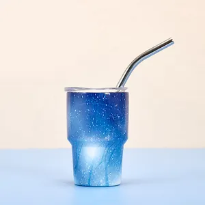 Gros plan d'un mini gobelet isotherme 3oz motif ciel étoilé bleu avec paille inox