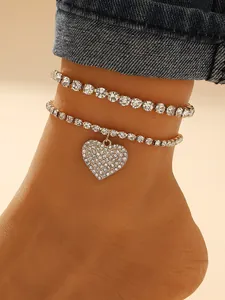 Close-up detail of sparkling rhinestone heart anklet set for summer beach wear