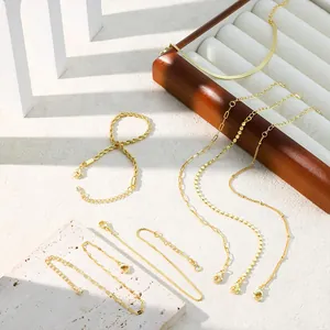 Vue macro détaillée de bracelets tendance à maillons et cordes dorés sur un plateau de luxe