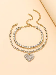 Close-up detail of a two-piece shiny heart rhinestone anklet set in a golden finish.