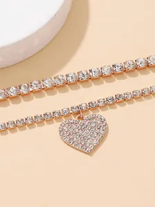 Close-up detail of shiny heart-shaped rhinestone anklet set in rose gold tone