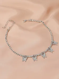 Silver butterfly rhinestone tennis chain anklet on champagne satin background