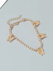 Detail of gold rhinestone anklet with shimmering butterfly charms for beach wear