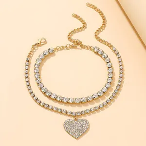 Glamorous gold-tone double-layered anklet set featuring a sparkling rhinestone heart pendant