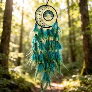 Detailed view of handmade moon dreamcatcher with tree of life and teal feathers in forest