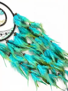Macro detail of handmade elf dreamcatcher with turquoise and green feathers and beads