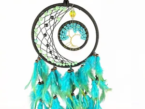 Detailed view of handmade dreamcatcher featuring tree of life and turquoise feathers