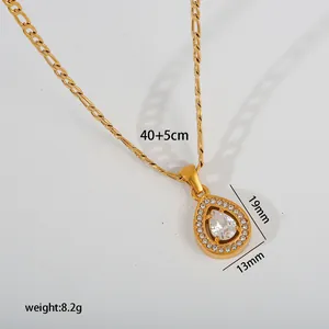 Close-up detail of a gold teardrop pendant necklace with sparkling clear crystals.
