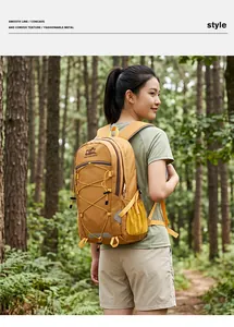 Frau mit großem orangefarbenem Wanderrucksack bei einer Trekkingtour im sonnigen Wald.