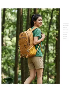 Asiatisches Model trägt einen großen senfgelben Wanderrucksack im üppigen grünen Wald