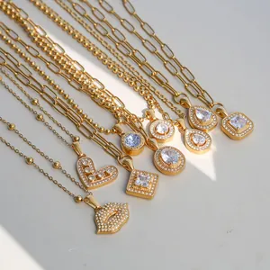 Detail of various gold stainless steel necklaces with crystal geometric pendants.