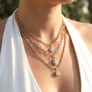 Detailed view of three-layered gold stainless steel necklace with crystal pendants.