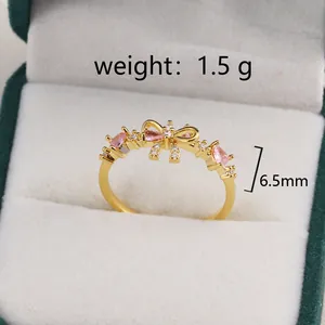 Makro-Detail des goldenen Schleifenrings mit rosa Zirkoniasteinen und 6,5 mm Höhe