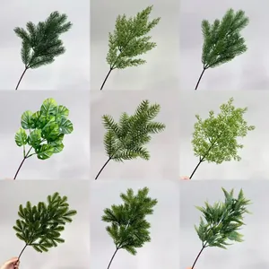 Detailed collection of nine artificial greenery branches including pine and monstera stems.