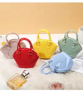 Collection of five colorful mini shell bags with textured pearl finish on a white fur surface