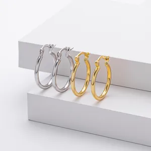 Close-up of high-quality smooth S925 sterling silver and gold hoop earrings on white blocks