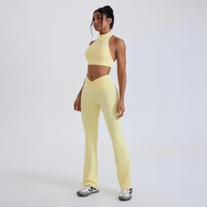 Full body view of a woman wearing a light yellow halter sports bra and flared yoga pants set