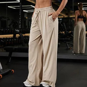 Athletic high-waisted wide-leg yoga lounge pants in beige shown in a gym setting