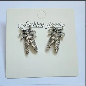Detailed macro view of vintage silver cicada insect stud earrings on display card.