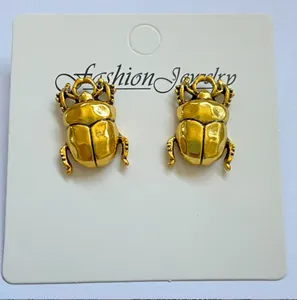 Detailed view of vintage gold beetle design on jewelry display card