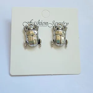 Detail view of vintage silver beetle jewelry mounted on a white display card.