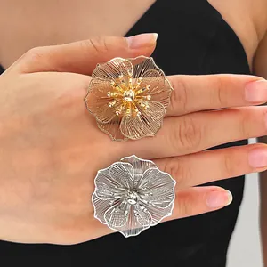 Primo piano di eleganti anelli a fiore traforato oro e argento indossati sulla mano per dettagli