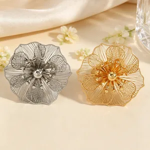 Dettaglio di eleganti accessori a fiori traforati con finiture in metallo oro e argento