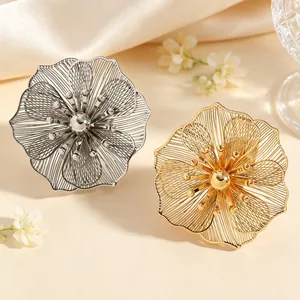 Primo piano dettagliato di squisiti orecchini a fiore cavo 3D in oro e argento dal design elegante