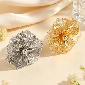 Primo piano dettagliato di anelli a fiore traforati in eleganti finiture oro e argento