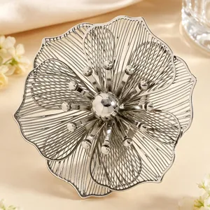 Dettaglio macro di un elegante gioiello a fiore traforato con finitura argento