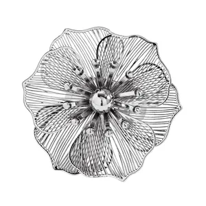 Primo piano di elegante accessorio a fiore traforato in argento con petali di metallo