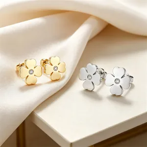 Detailansicht eleganter Blumen-Ohrstecker in Gold und Silber mit funkelnden Zirkonia-Steinen.