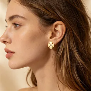 Detailansicht der eleganten goldenen Kleeblatt-Ohrstecker mit kleinem Kristall am Modell